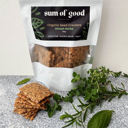 Bag of Sum of Good Mixed Herbs crackers with a stack of crackers and fresh oregano, thyme and basil